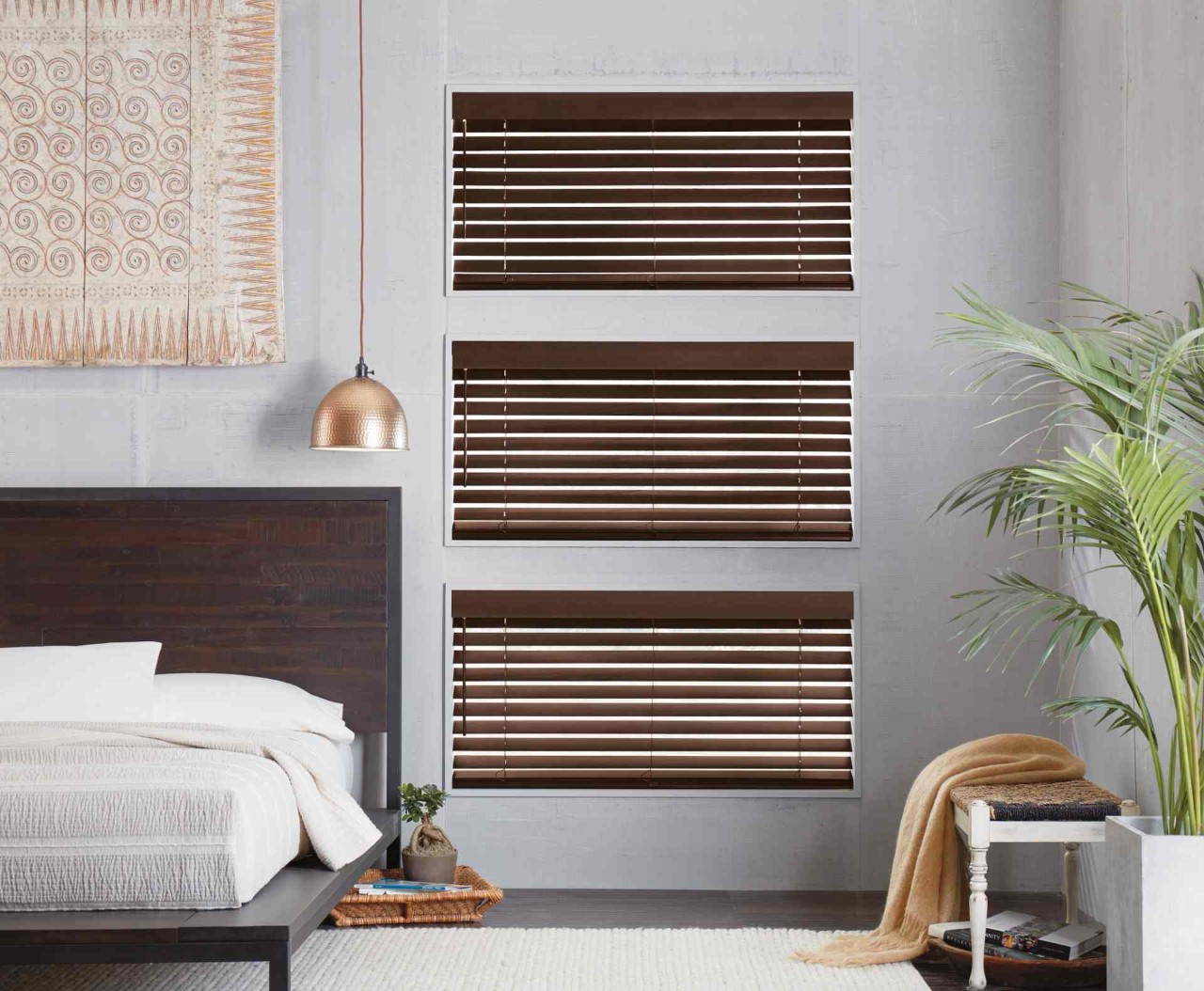 Three sets of wooden bedroom blinds in a bedroom near Flower Mound, TX.